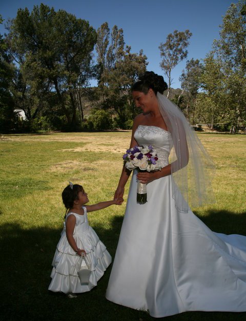 A bride and her flower girl share a special memory together at Peter Strauss Ranch.