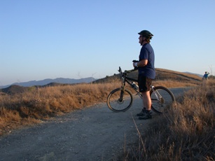 A mountain biker takes a moment to enjoy views of the park from a rise.
