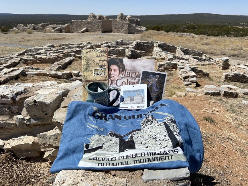 Souvenirs from the bookstore are arranged in front of the ruins of a limestone church.