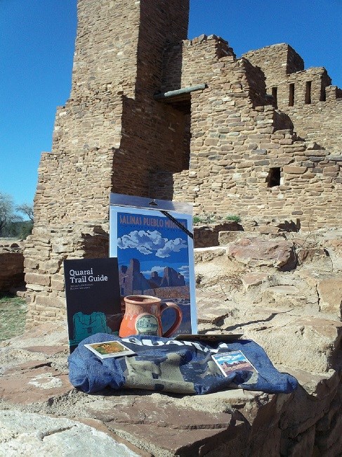 Souvenirs from the bookstore are arranged in front of the ruins of a red sandstone church.