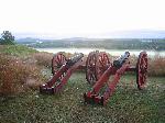 Two lone cannons overlook a misty river valley