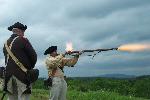 A man firing a Revolutionary War style musket