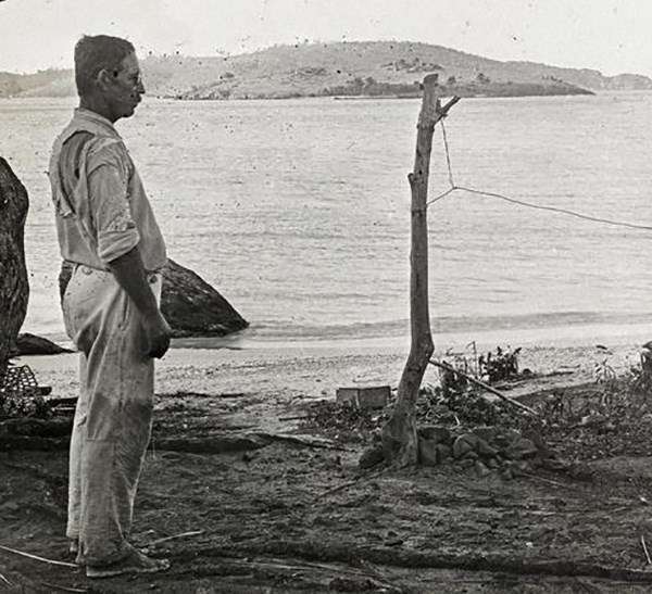 photograph of archeologist Gudmund Hatt standing on the shoreline at Salt River