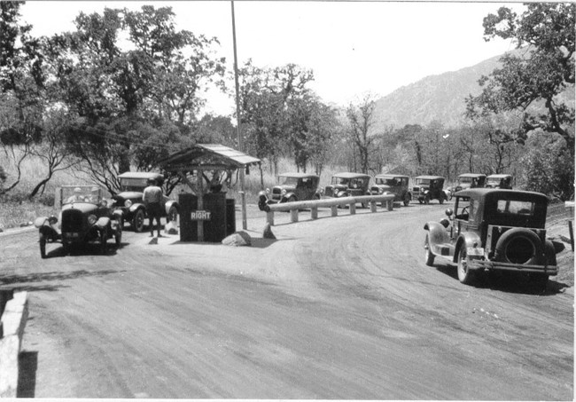 vintage autos line up at the park entrance