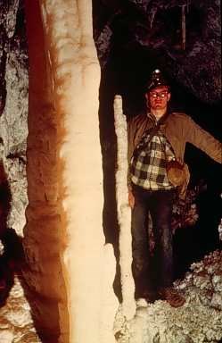 Man stands beside a clean Soldier Cave formation as it was in 1950