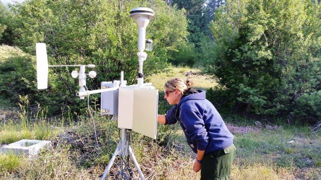 Ariane Sarzotti works with a portable particulate monitoring station known as an E-BAM to measure impacts from smoke caused by area fires. (Photo: NPS / Mike Theune)