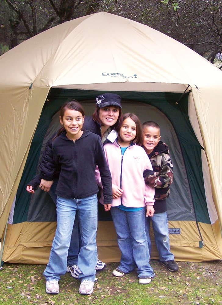 A CAMP family in front of their tent.