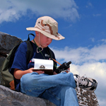 A young visitor studies his GPS unit while earthcaching at Blackrock summit.