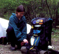 A backcountry camper sets up her campsite. A backcountry camper sets up her campsite.
