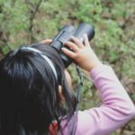 Girl looking through binoculars.