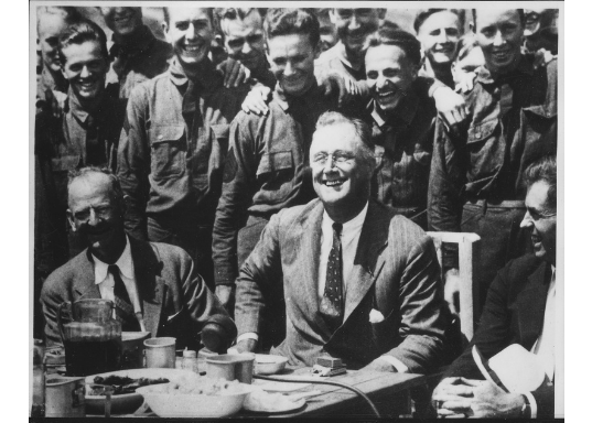 Black and white image of FDR surrounded by men.