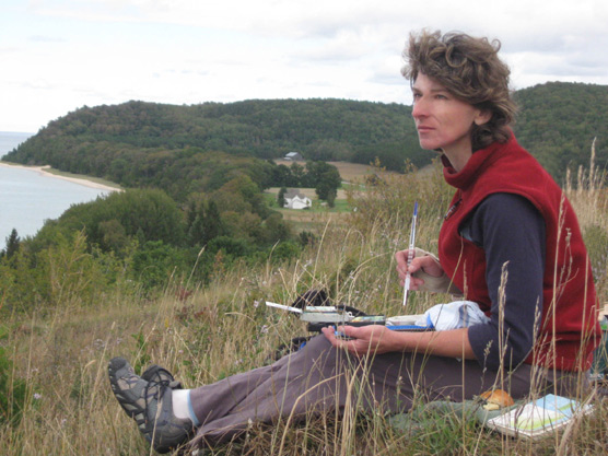 Airtist-in-Residence Kaye Krapohl sketching in Sleeping Bear Dunes National Lakeshore.  Photo courtesy of National Park Service.