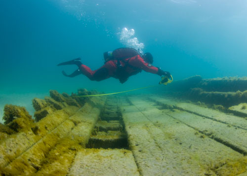 diver measures a shipwreck