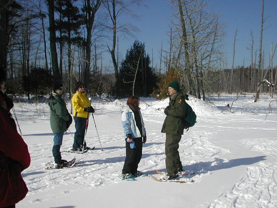 Park Ranger Peg Burman snowshoes with visitors at Tucker Lake in the National Lakeshore.  Photo courtesy of the National Park Service.