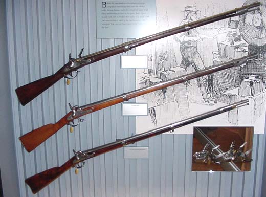 This case displays three early Springfield Armory muskets and two flintlock mechanisms.