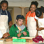 Middle school students from Chestnut School in Springfield, MA, shown in a simulation making musket parts.
