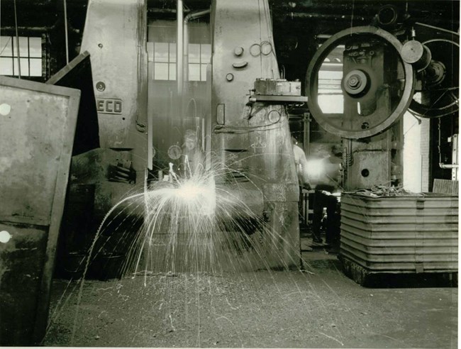 Sparks fly from a forging machine