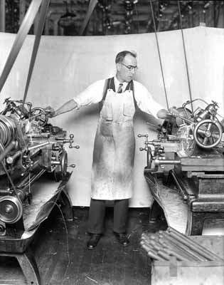 An Armory worker demonstrating metal-cutting lathes, c1920s