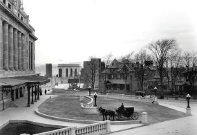 A horse-drawn carriage stands outside the 1908 DL&W Railroad's passenger station in the 1908 black and white photo.