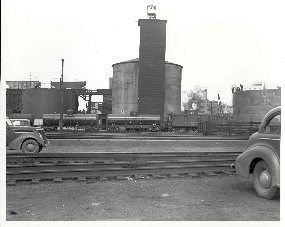 A black and white photo from 1951 showing the sand drying tower with railroad tank cars and period automobiles.