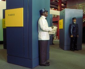 In Steamtown's History Museum, the Life on the Railroad section includes full size multicolor mannequins showing the different jobs of railroading.  The Pullman Porter wears blue slacks, a white jacket, bow tie, and blue cap.  He carries a small stack of sheets.