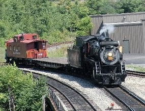 CN 3254, a freight locomotive built in 1917, pulls a flatcar and a Delaware, Lackawanna & Western caboose in the Scranton railroad yard.