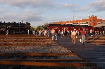 Visitors, walking on connecting boardwalk to parking area, depart an excursion train