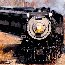 Learn about Steamtown's operating locomotives.  A steam locomotive pulls a passenger train through the woods.