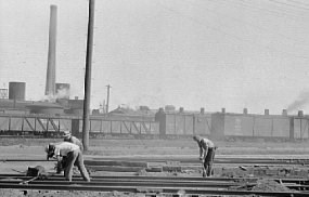 Three workers in a railroad yard.  Historic Photo.
