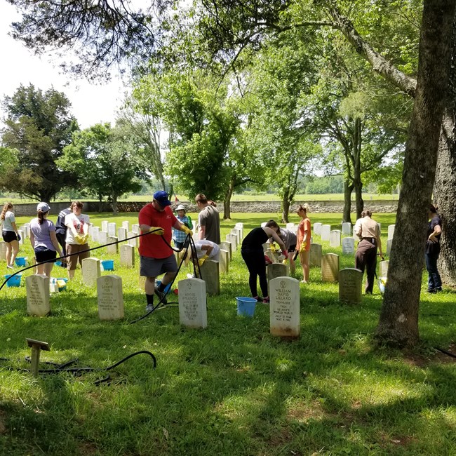 group of volunteers cleaning headstones