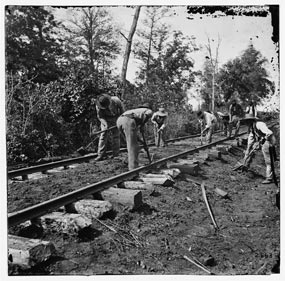 Black soldiers repairing a railroad track.