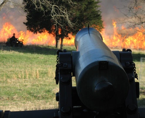 Fire burns in front of a cannon.