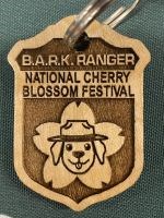 Wooden badge with a picture of a dog and the words "Bark Ranger"