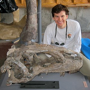 person next to large fossil skull