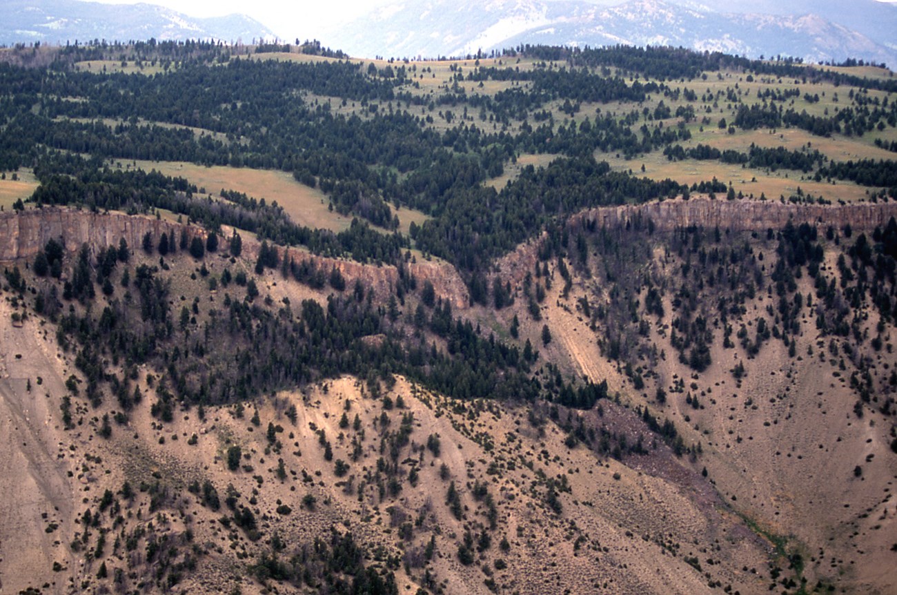 Aerial photo of a mountain with a prominent banded cliff face.