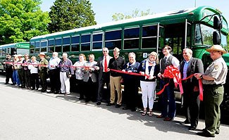 DOE and NPS employees present a new, energy efficient bus during a ribbon cutting ceremony.