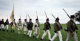 Volunteers in period clothing reenact the War of 1812.