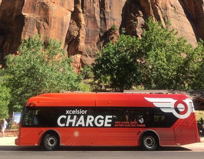 Electric Bus in front of rock formation at Zion