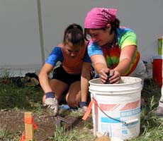 Two girls work together on an excavation.