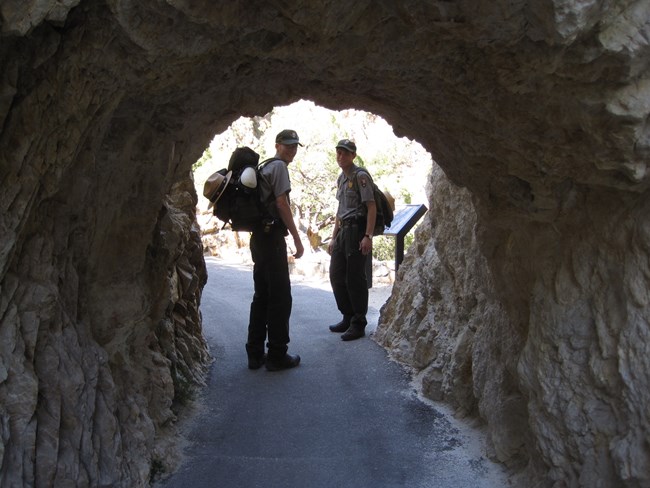 People-rangers at tunnel on trail