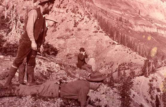 George Tyng and his two sons, Francis & Charles, looking into Mineral Basin.  CH Joy is the photographer looking through binoculars. Reddish toned, black and white image with big views from Miller Hill.