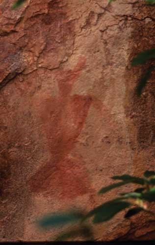 Fremont pictograph; series of rust red triangles resembling a person on sand colored rock.