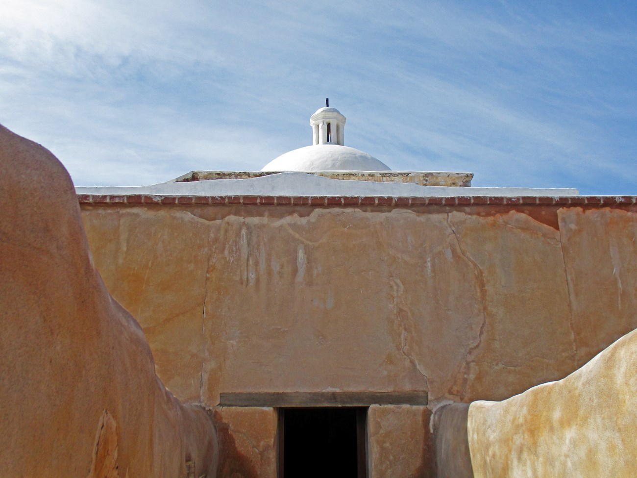 Adobe buildings with a centered doorway.