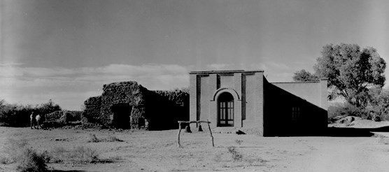 historic photo of church with exposed adobe ruins of older church to the left