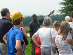 A volunteer giving a tour to a group of visitors along the rise where the outer line defences once stood.