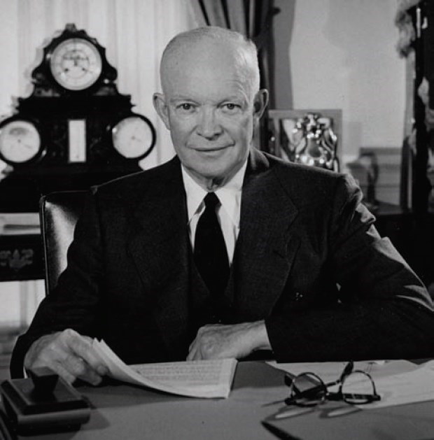 President Eisenhower sits at a desk.