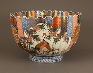 A colorful fluted, deep bowl painted with image of cranes.