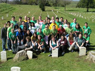 University of Iowa Students pose in front of the headstones they cleaned in Vicksburg National Cemetery.