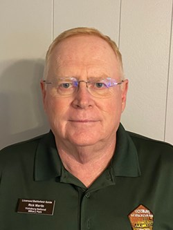 A man looking at the camera with red hair and glasses.