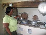 A cultural practitioner demonstrates cooking on a stove in the kitchen of a 200-year-old Danish sugar mill plantation in Virgin Islands National Park.